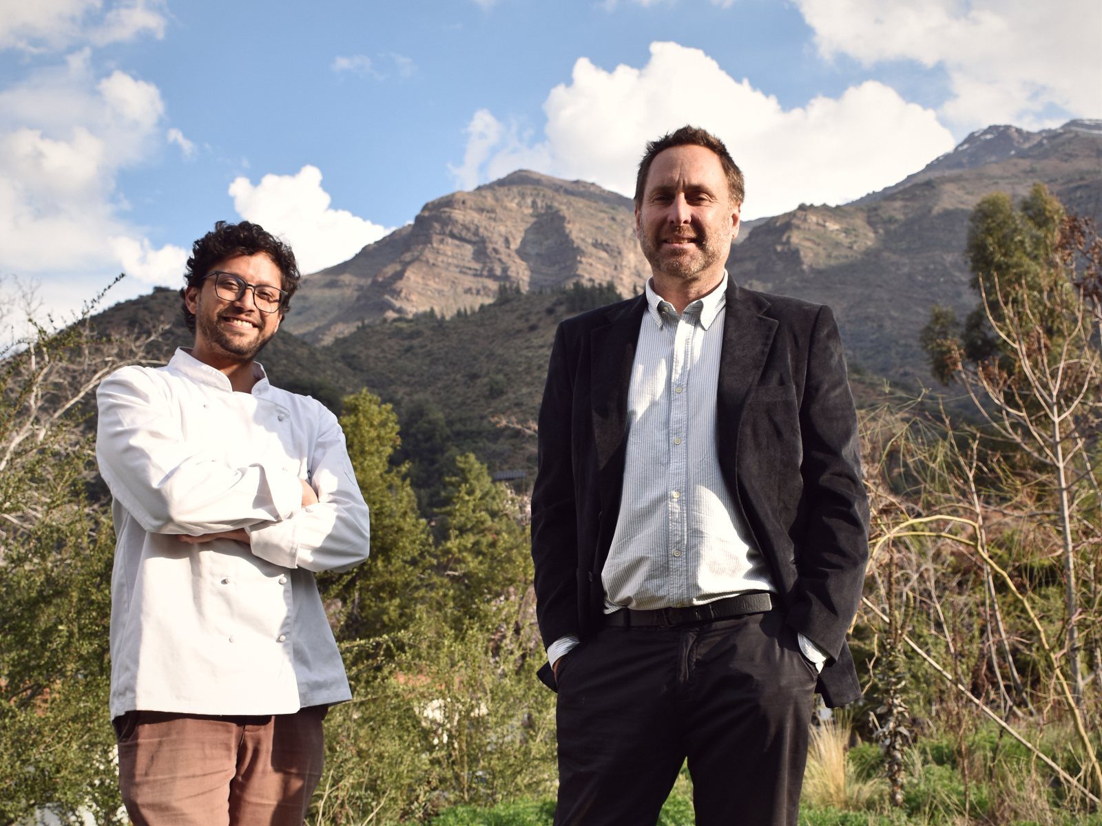 Kurt Thiele, con chaqueta de chef, y Germán Ilabaca frente a la cordillera