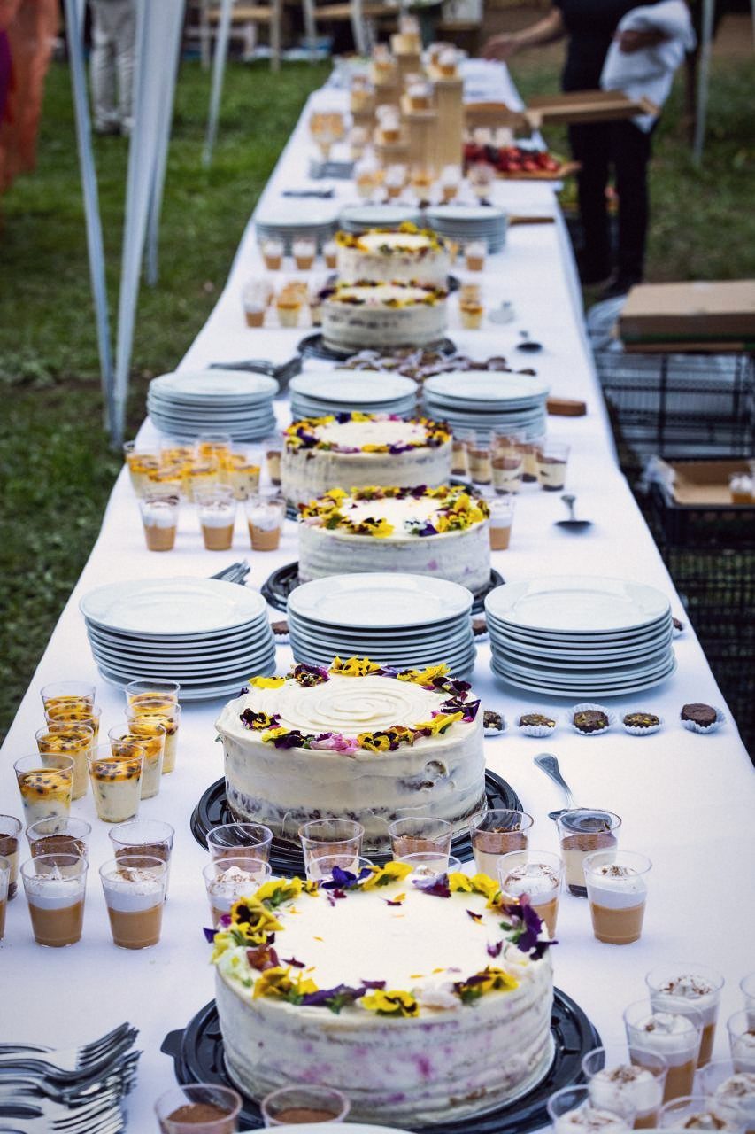 Mesa de postres con tortas y flores comestibles
